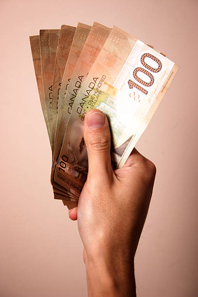 mano holding banconote da 100 dollari canadesi - banconota di dollaro canadese foto e immagini stock