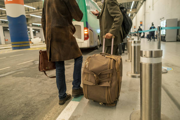 istock two men holding their baggage wait for shuttle after air travel in bus stop 1470162331
