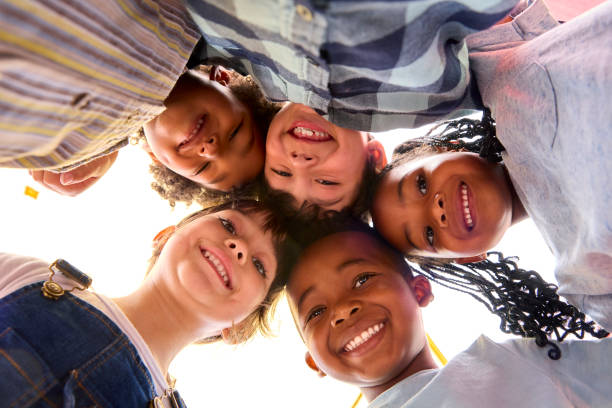istock Low Angle Portrait Of Smiling Multi-Cultural Children Looking Down Into Camera 1470163138