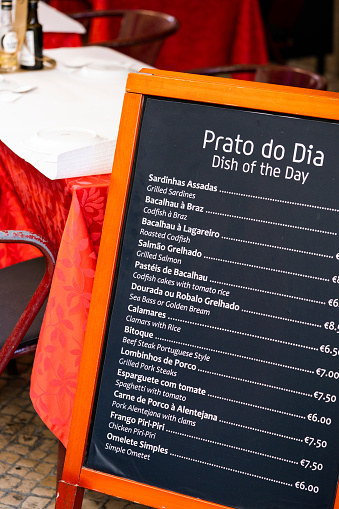 Menu of outdoor restaurant with names of traditional dishes in Spanish and English.