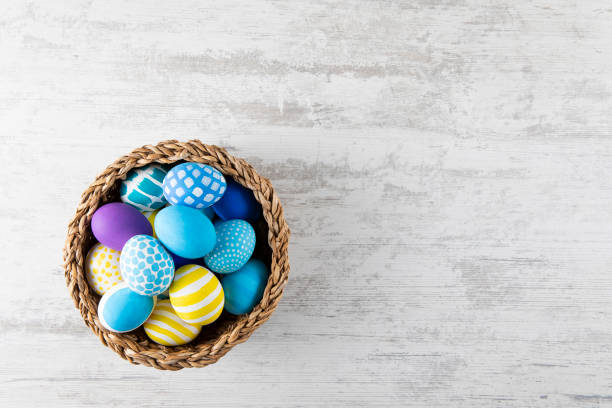 istock Easter Eggs in a Basket on White Wooden Background 1470165431