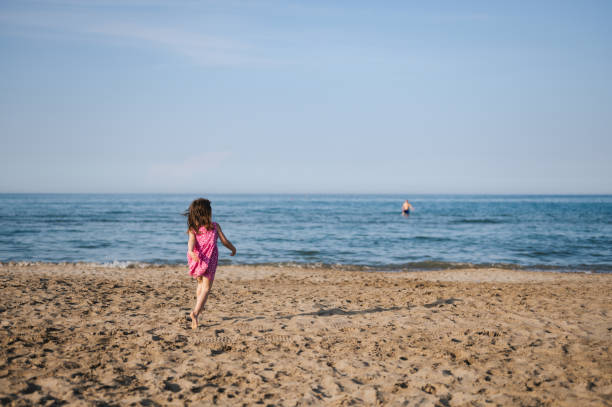 istock full length  little girl running on a sandy beach . copy space. 1470165883