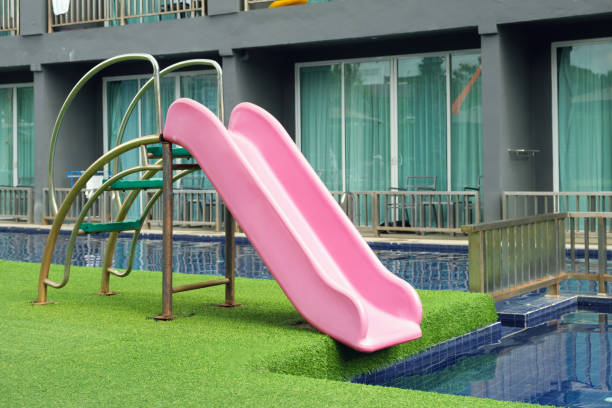 istock Pink plastic slide for children in the swimming pool 1470167808