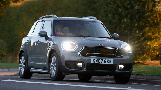 Bicester,Oxon,UK - Oct 9th 2022. 2017 hybrid electric Mini Countryman with headlights on, driving on an English country road