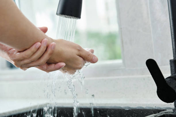 istock Woman washing hands under running water 1470170111