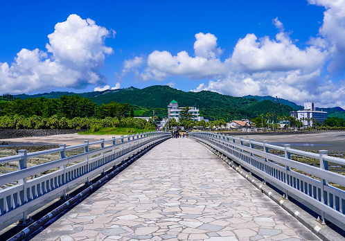 Yayoi Bridge and Demon's Washboard over sunny Aoshima Island on a sunny day in June 2022 at Nichinan Kaigan in Miyazaki City, Miyazaki Prefecture