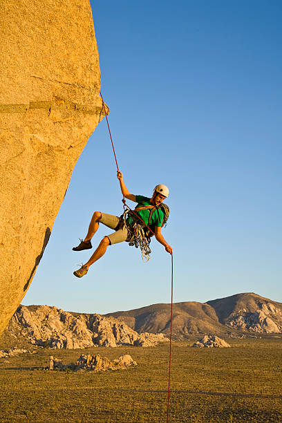 Rock climber rappelling. stock photo