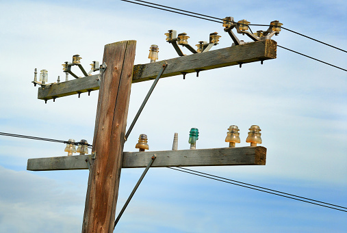 Old wooden telephone pole with vintage glass insulators.