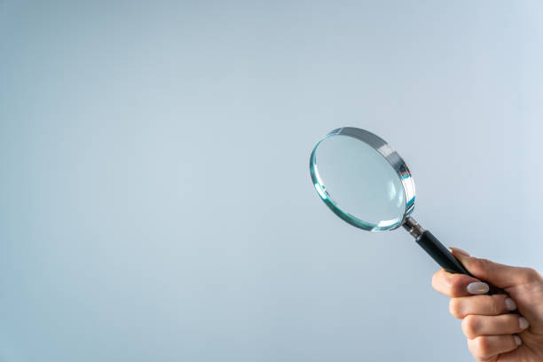 istock Young woman holding magnifying glass 1470173163