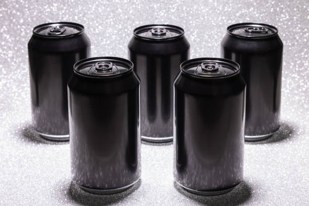 istock Five black blank aluminium cans on a white background with glitter under hard light (selective focus) 1470173225