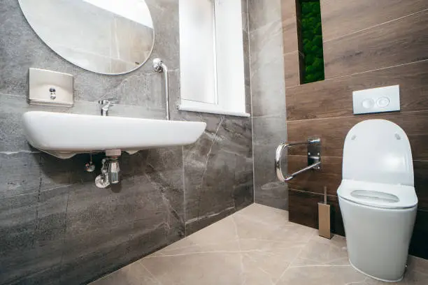 Photo of Interior of modern toilet with handrail