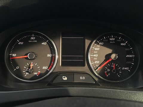 Close-up of car dashboard speedometer panel with sunlight reflection