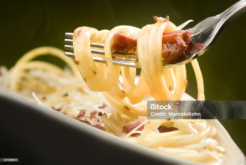 spagetti carbonara Close up to a fork rolled with spagetti carbonara Carbonara Sauce Stock Photo