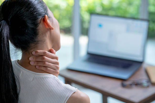 młoda azjatka cierpiąca na ból szyi i ramion w domowym biurze - pain human neck working rear view zdjęcia i obrazy z banku zdjęć