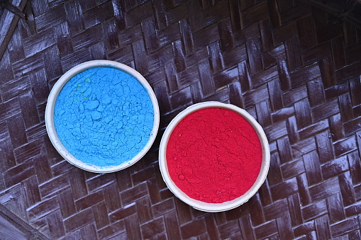 top view of Colorful traditional holi powder in bowls isolated on dark background.Space for text . happy holi.Concept Indian color festival called Holi