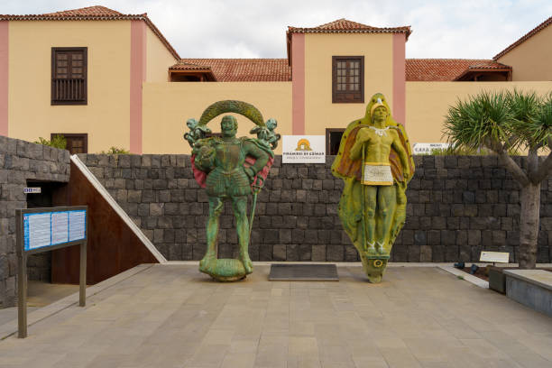 Güímar, Canary Islands, Spain - December 15, 2022: This beautiful photo of statues of the conqueror and the conquered is set against a 19th century Canarian building. It reminds us of the power and dominance of one group over another. These statues are often used to commemorate significant historical figures and events, and to celebrate the achievements of a particular group or society. They also serve as reminders of the strength and power of one group over another.
