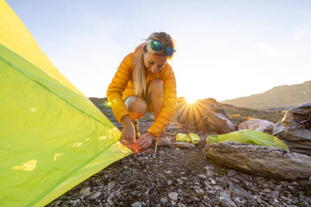 istock Woman setting up tent outdoors in Norway 1470197737