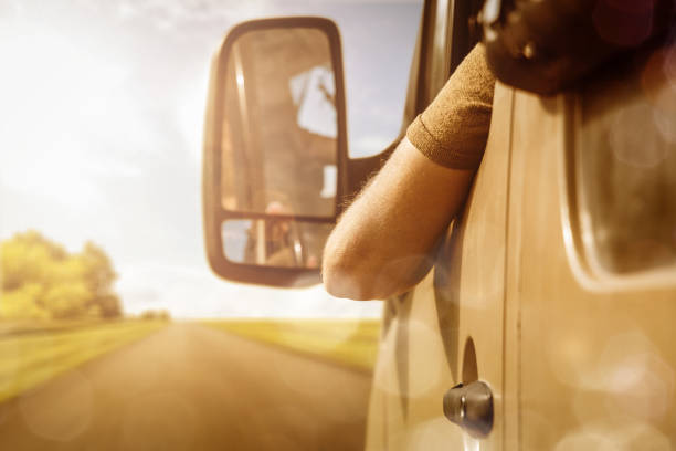 Arm of a van driver hanging out of the window stock photo