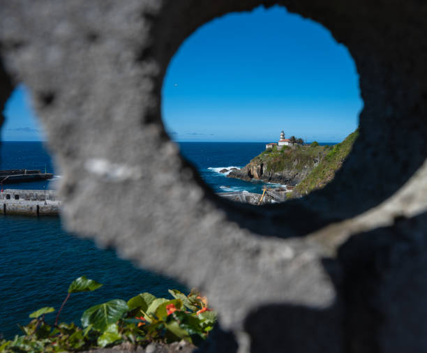 View of a lighthouse through a hole in a wall