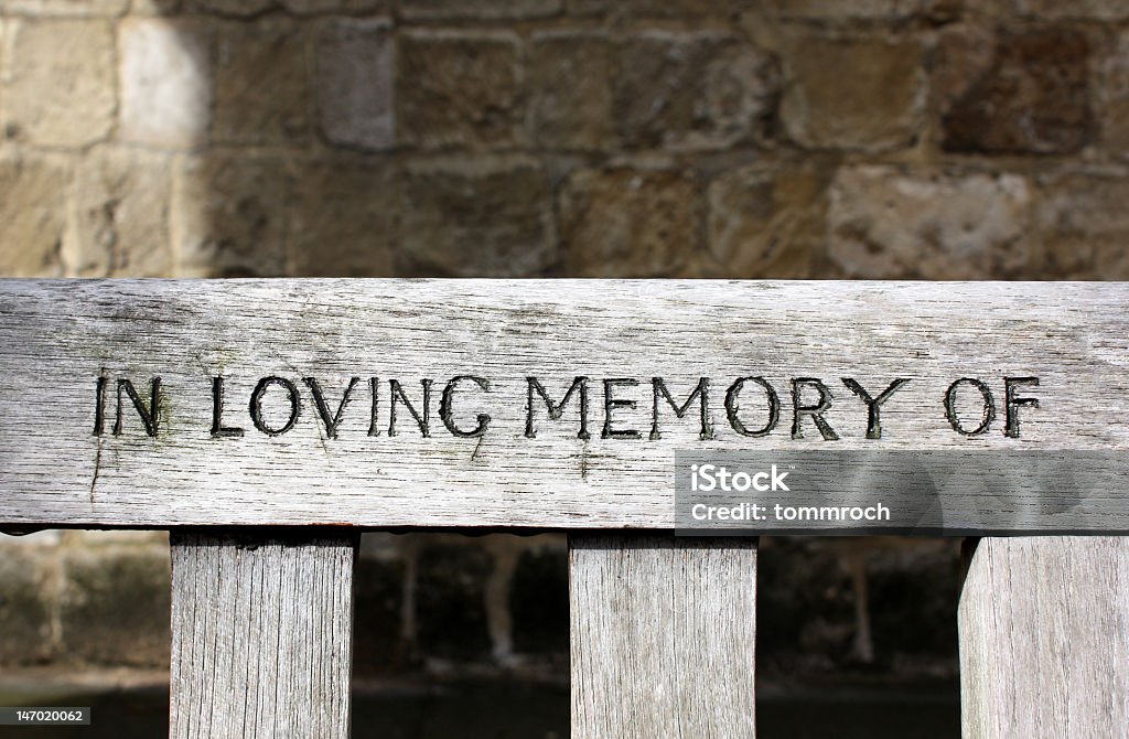 In loving memory of The words In loving memory of, carved into grainy, textured wood Love - Emotion Stock Photo