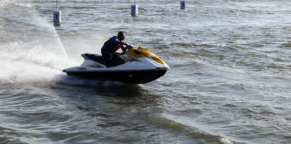 An Action picture of a Jet ski scooter and its rider speeding through the Ocean waters in Kochi city of Kerala in India.