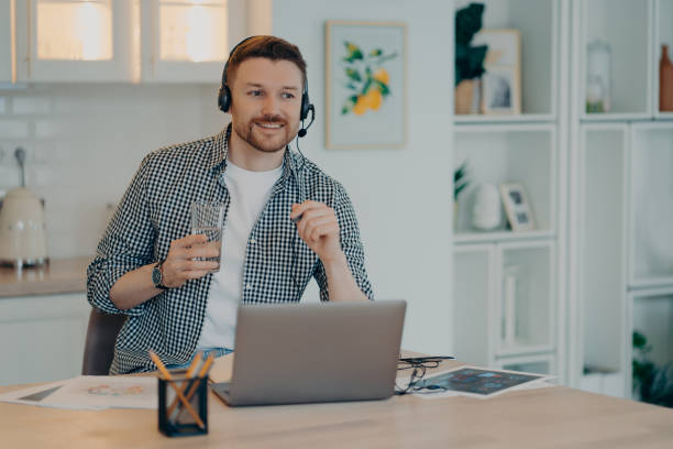 istock Happy man in casual clothes going to make notes in notebook while studying at home 1470204189