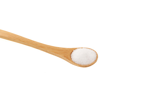 Isomalt or Isomaltitol  powder in wooden spoon, close-up. Disaccharide derived from sucrose, isomaltulose. Food additive E963, sweetener, sugar substitute.