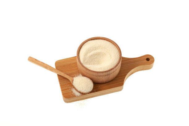 istock Wheat semolina in wooden bowl on cutting board. White background, copy space 1470204454