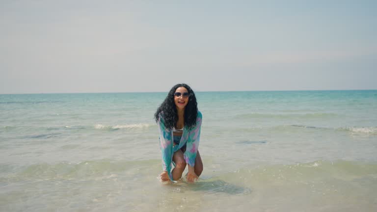 Young women play in the sea on their summer vacation and they smile and are happy on vacation.