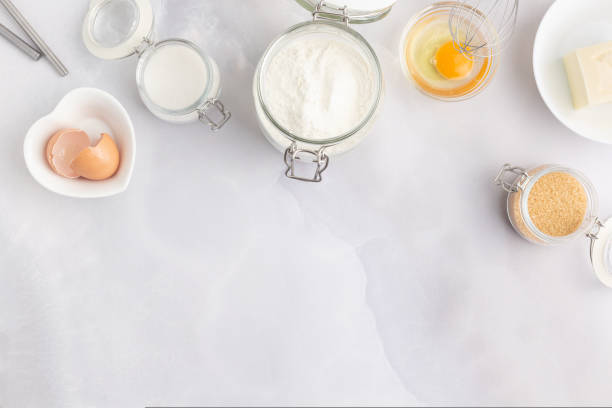 istock Various baking ingredients - flour, eggs, sugar, butter and kitchen utensils on grey background. Top view. 1470206661