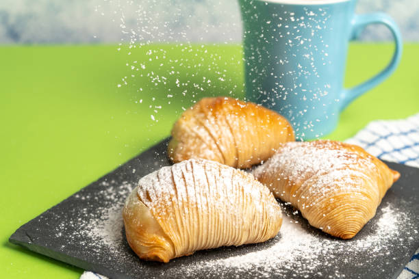 Delicious Sfogliatella: typical and traditional Italian sweet of Neapolitan cuisine filled with ricotta and sprinkled with fine sugar with a cup of coffee. stock photo
