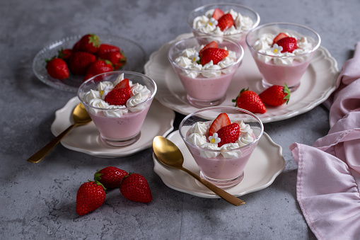 Homemade fresh strawberry mousse dessert on a concrete background.