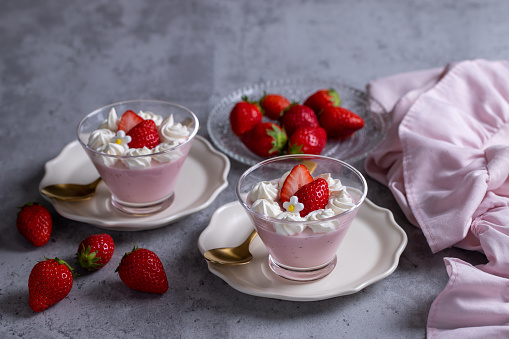 Homemade fresh strawberry mousse dessert on a concrete background.