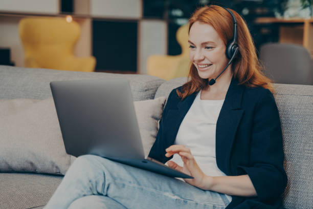 istock Young positive gingerhead female student having online webinar via laptop and headset in coffee shop 1470207165