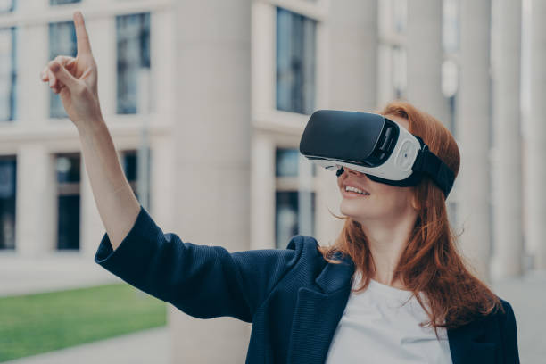 istock Happy young businesswoman using virtual reality goggles while standing outdoors 1470207204
