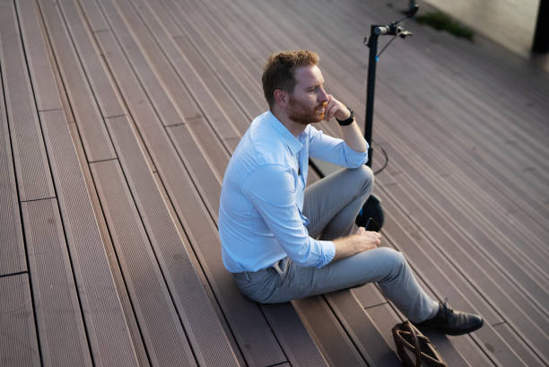 istock Businessman using the phone while sitting on the stairs 1470208712