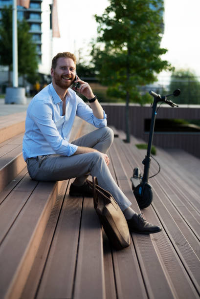 istock Businessman using the phone while sitting on the stairs 1470208716