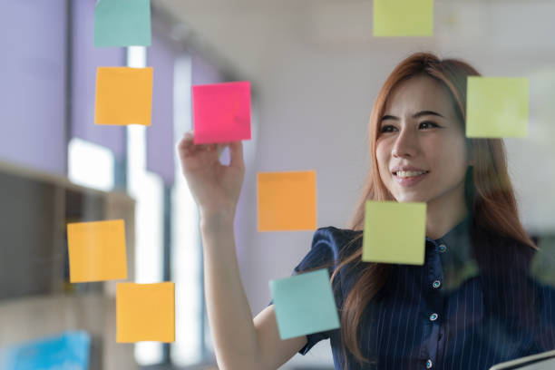 istock Confident businesswoman planning while looking at adhesive notes stuck on a glass wall. 1470209148