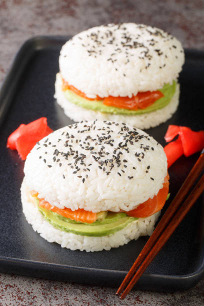 istock Sushi burger with avocado and a salmon on a dark background. Vertical 1470209407