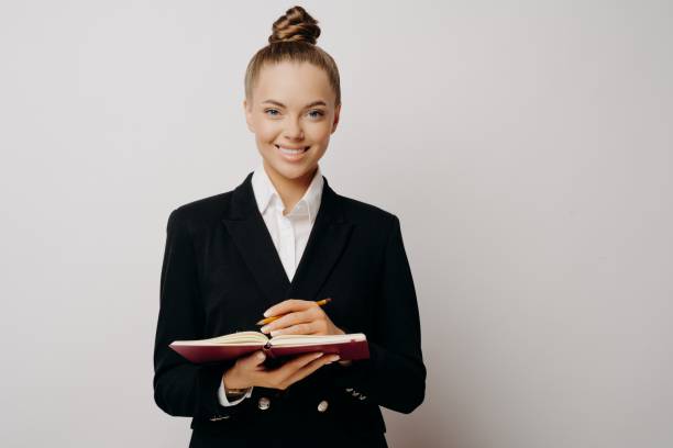 istock Business woman in dark suit writing in note book 1470209822
