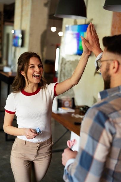 Cheerful coworkers giving high five stock photo