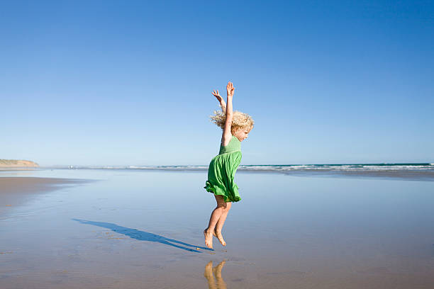 Child jumping on beach stock photo