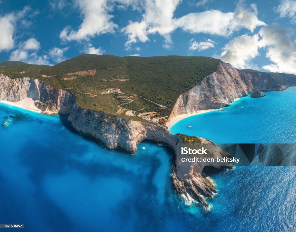 Aerial view of blue sea, mountains, sandy beach at sunny day in summer. Panorama. Porto Katsiki, Lefkada island, Greece. Beautiful landscape with sea coast, rocks, water, sky with clouds. Drone view Lefkada Island Stock Photo