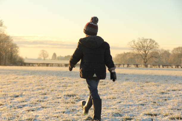 istock Boy walking through field of snow 1470216263