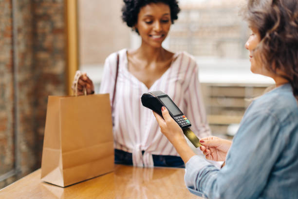 istock Female ceramic store owner swiping a credit card while serving a customer 1470216314