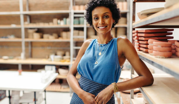 istock Young potter smiling at the camera in her shop 1470216409