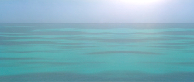 The landscape is a beautiful turquoise sea and the horizon at dawn. Banner. Blurry image.