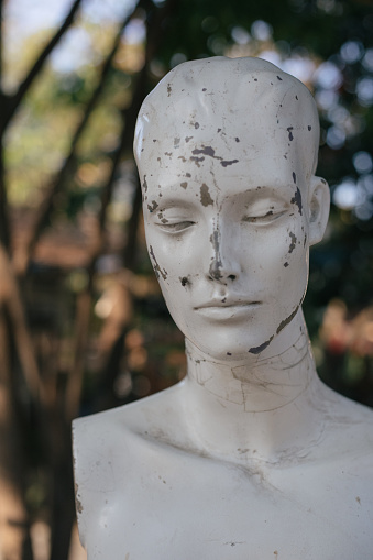 Close up of white mannequin dummy statue with cracks in it's fake plastic skin idea of beauty skin deep