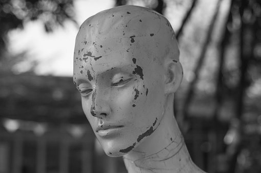 Concept of stress and anxiety damaged female mannequin head outdoors