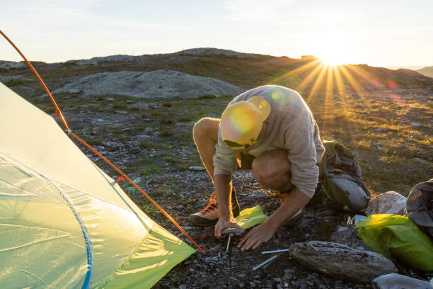 istock Man setting up tent outdoors in Norway 1470218260